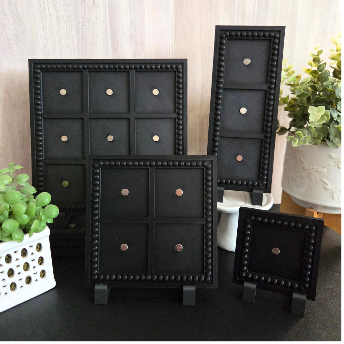 Black 3D‑printed 3×3 magnetic frame with a decorative beaded border, designed to hold nine photo magnets in a clean grid layout, shown with removable feet and clearly labeled as holding 9 photo magnets.