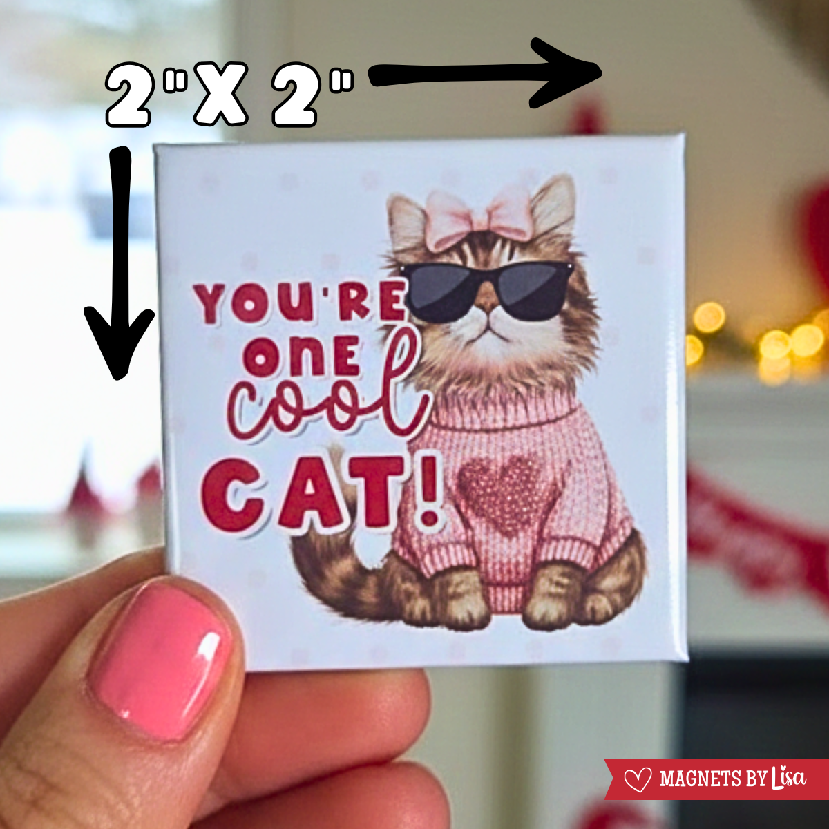 A valentine's day themed magnet that features a cat with text that reads "You're one cool cat!" in the colors or red and pink. THe cat is wearting sunglasses and a pink sweater with a heart in the middle. and a pink bow in it's head.