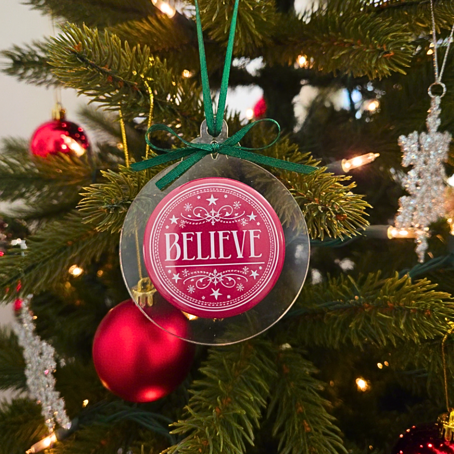 Christmas ornament with 'BELIEVE' text on a decorated tree