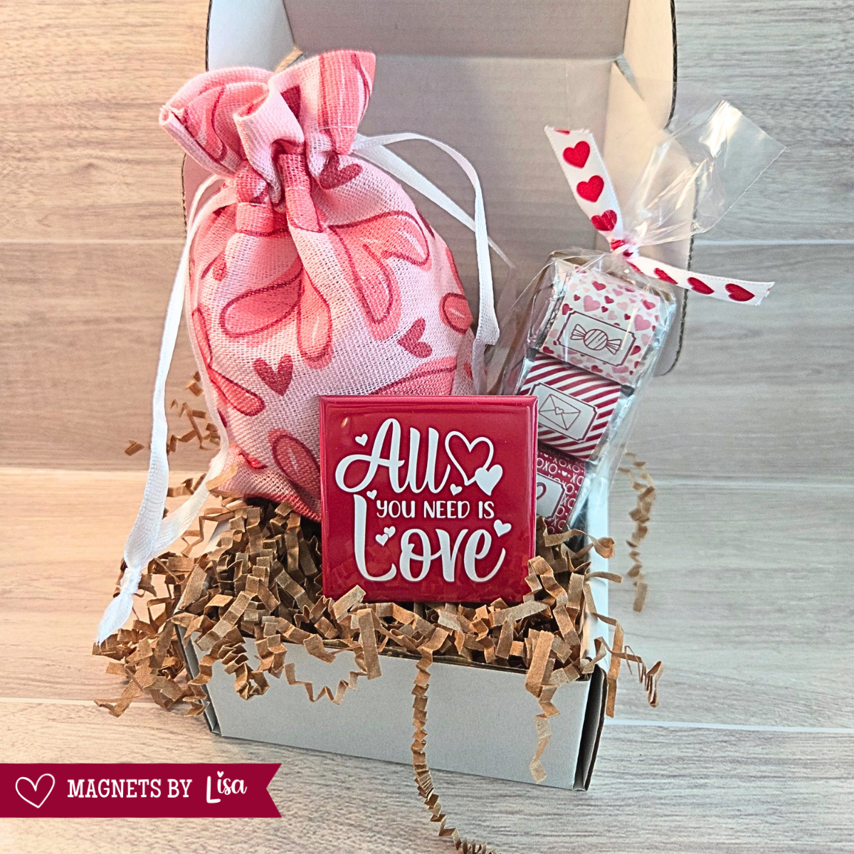 Valentine Day Themed gift with 4 piece magnetic puzzle, All You Need is Love Magnet and a trio of Hershey Milk Chcoclate Nuggets. 