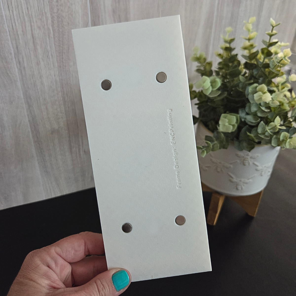 White three‑magnet display back side frame with a beaded border and built‑in front magnets, shown standing on a tabletop.