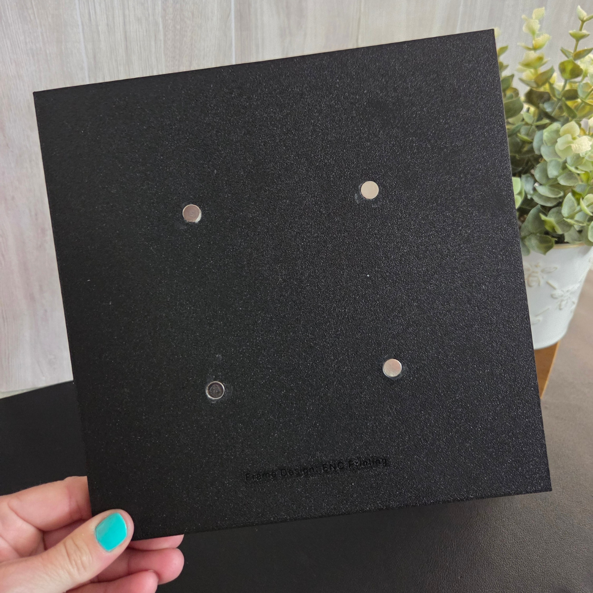 Black 3D‑printed 3×3 magnetic frame with a decorative beaded border, designed to hold nine photo magnets in a clean grid layout, shown with removable feet and clearly labeled as holding 9 photo magnets.