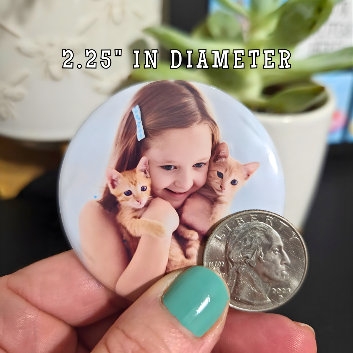 Button badge with a girl holding two kittens, compared to a quarter for size reference.