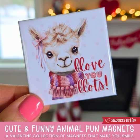 A valentine's day themed magnet that features a Llama with text that reads "Llove you Llots" in the colors or red and pink.  The llama is wearing a red, purple. pink and white scarf and pink pom poms around its neck. 