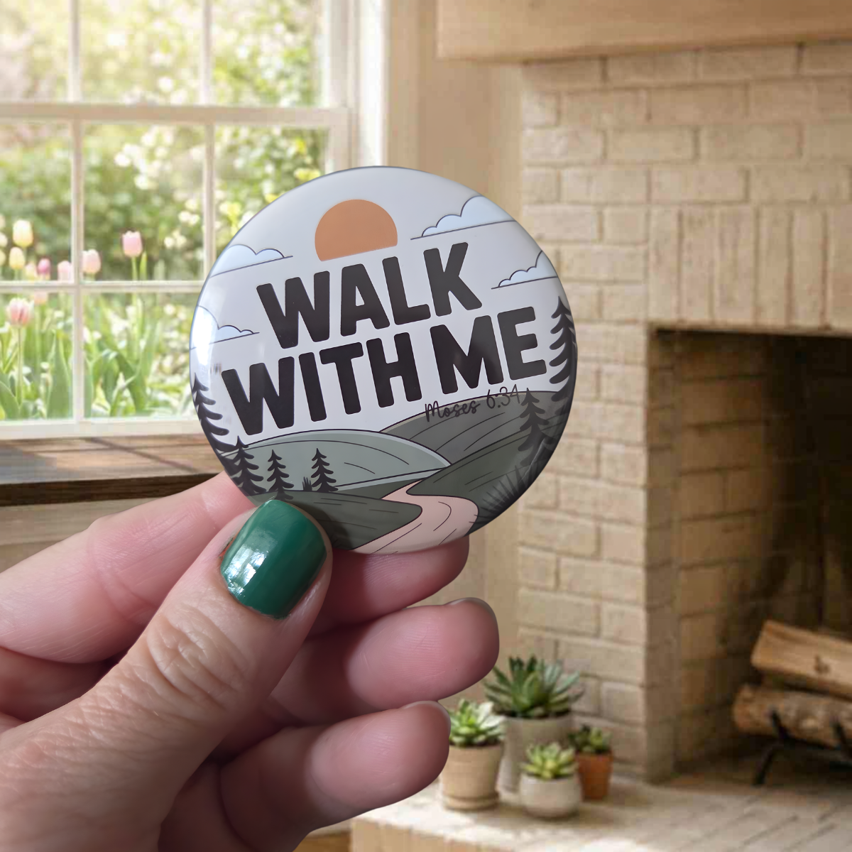   
“Round ‘Walk With Me’ pin featuring a winding path through hills and trees under a rising sun, with the scripture reference Moses 6:34